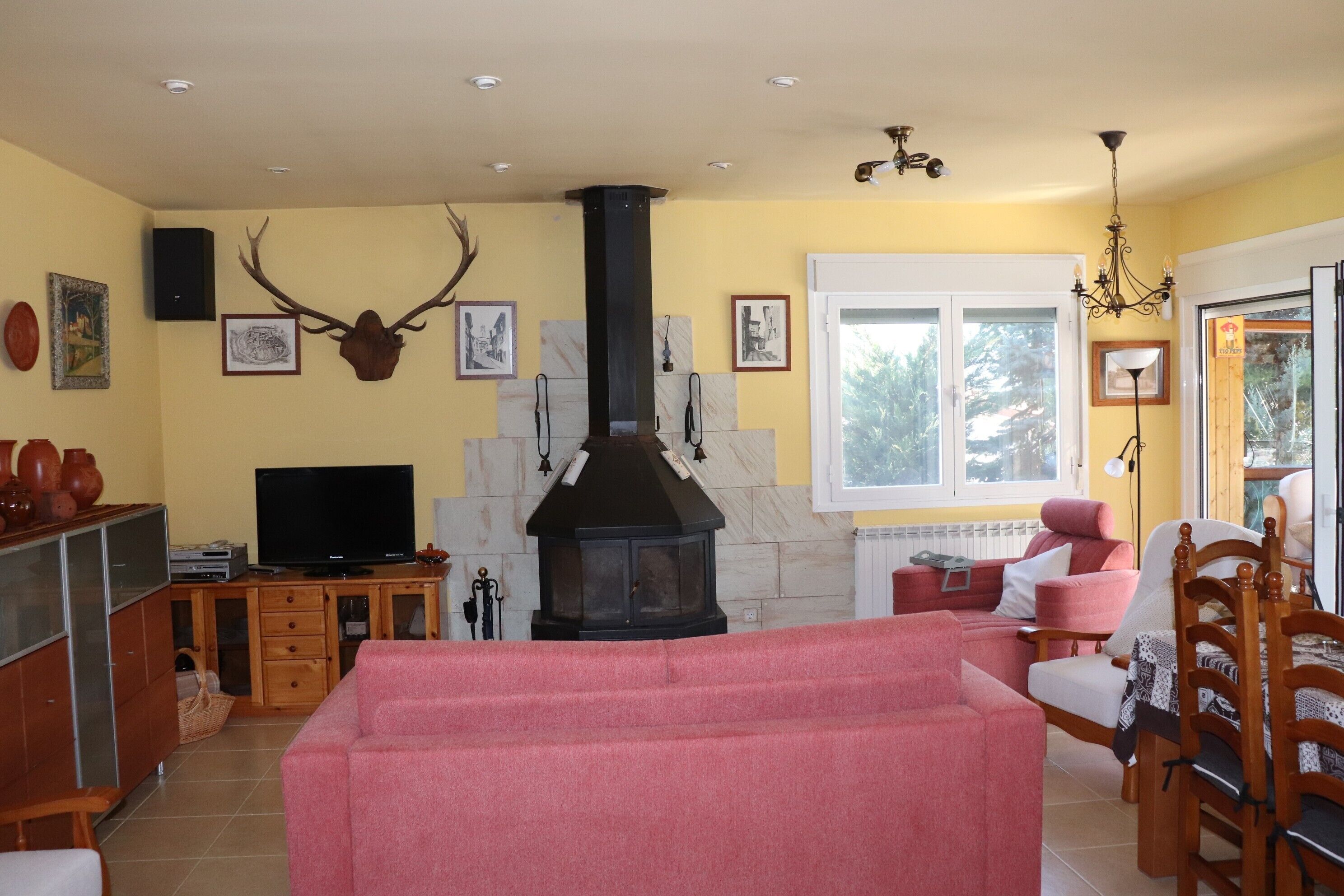 Una sala de estar con chimenea, televisor y sofá.