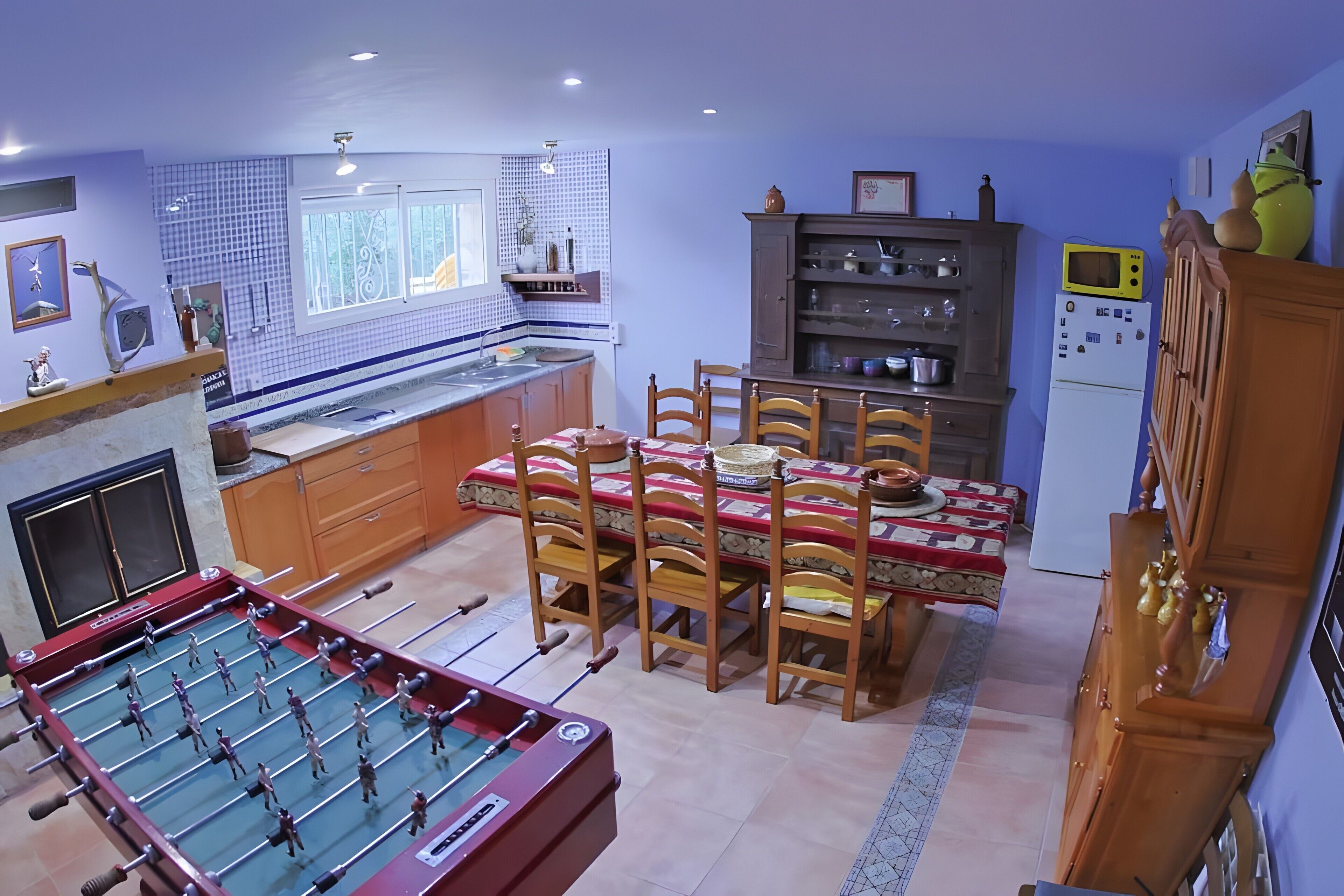 Una cocina con mesa de futbolín, mesa de comedor y sillas.