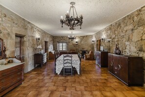 Una habitación con paredes de piedra, una mesa de madera y un candelabro.