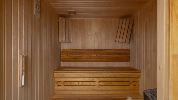 Eine Sauna mit Holzbänken und schrägverlaufender Decke.