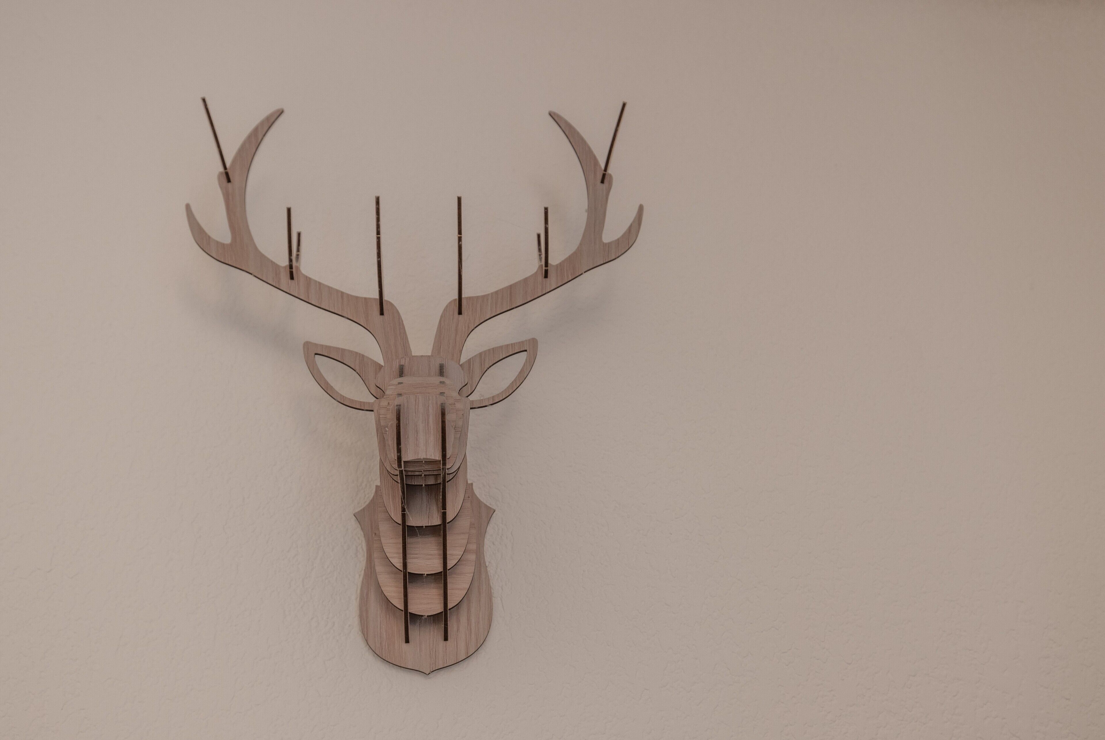 A wooden deer head mounted on a wall.