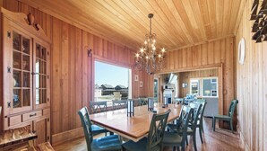 Un intérieur en bois comprenant un coin repas, des meubles de rangement en bois et un lustre.
