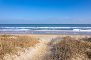 A beach path leading to the ocean with dunes and a wooden fence. - Hawk's Nest: Semi-Oceanfront, Hot Tub, Close to Beach Access (Nags Head)