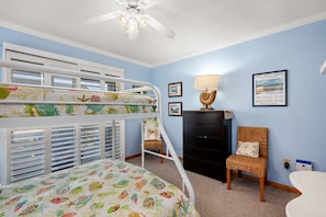 A child's bedroom with bunk beds, a desk, a chair, and a ceiling fan. - Hawk's Nest: Semi-Oceanfront, Hot Tub, Close to Beach Access (Nags Head)