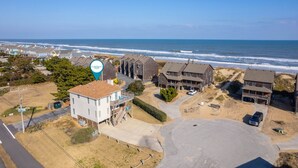 Un quartier résidentiel situé sur la côte, avec des maisons à proximité de la plage, caractérisé par un mélange d’architecture moderne et traditionnelle.