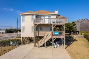 A two-story house with a wooden deck and a sign indicating it is a Coastal Carolina property. - Hawk's Nest: Semi-Oceanfront, Hot Tub, Close to Beach Access (Nags Head)