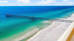 A beach with a pier extending into the ocean.
