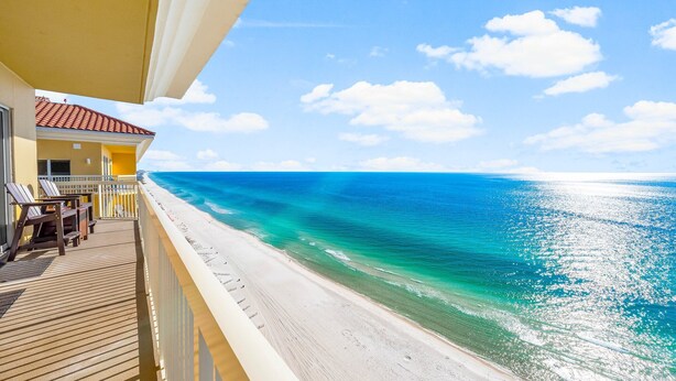 A balcony with a view of a beach and ocean.