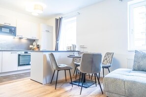 Una cocina moderna con comedor, sofá y ventana.