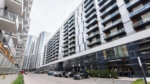 A modern high-rise building with multiple balconies and a storefront named "HOOKAHTEKA".