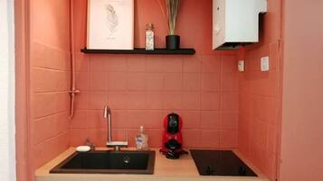 Een koelkast, een microgolfoven, kookgerei, borden en bestek