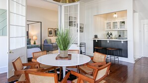 Un espace repas avec une table ronde, des chaises en bois et une plante au centre.