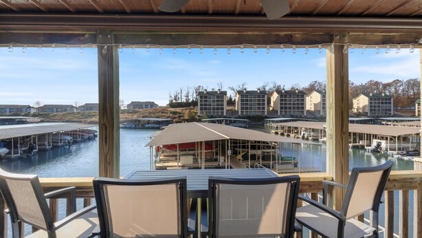 Un'area salotto all'aperto coperta con vista su un porto turistico e palazzi.