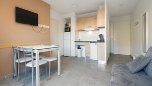 A modern apartment with a dining area, kitchenette, and living room. - Nice villa for 6 pers with garden (Sérignan)