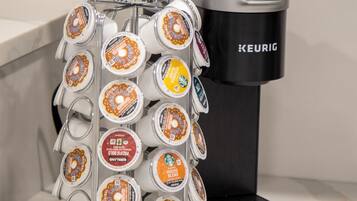 A coffee maker with a drip tray holding multiple coffee pods.