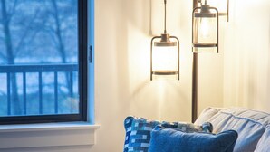 Un soggiorno moderno con un divano, cuscini decorati e una lampada da terra.