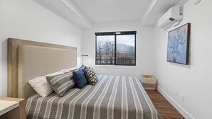 Una camera da letto con un letto, una finestra e un condizionatore d'aria.