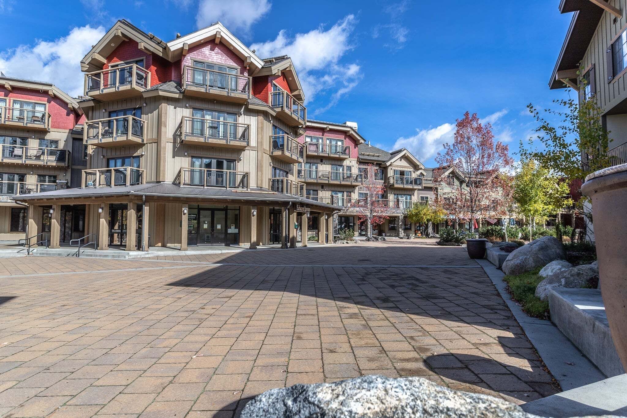 A multi-story hotel with balconies, a paved courtyard, and a clear sky.