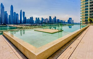 Un hôtel moderne doté d’une piscine à débordement sur le toit, offrant une vue imprenable sur le paysage urbain.
