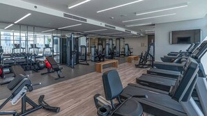 A modern gym with treadmills, weight machines, and free weights.