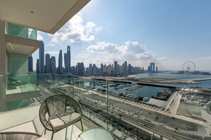 A balcony with a city view, including a marina and skyscrapers. - Stylish Emaar Beachfront 2BR w/ Beach Access (Dubai)