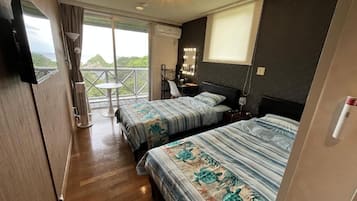 A hotel room with two beds, a balcony with a view, a vanity with a mirror, and a television.