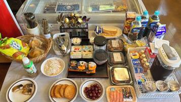 A buffet table with various food items, including bread, cheese, and seafood.