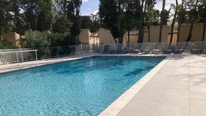 A rectangular swimming pool with clear blue water, surrounded by a white fence and a tiled deck. - Cottage Saint-remy-de-provence (St.-Rémy-de-Provence)