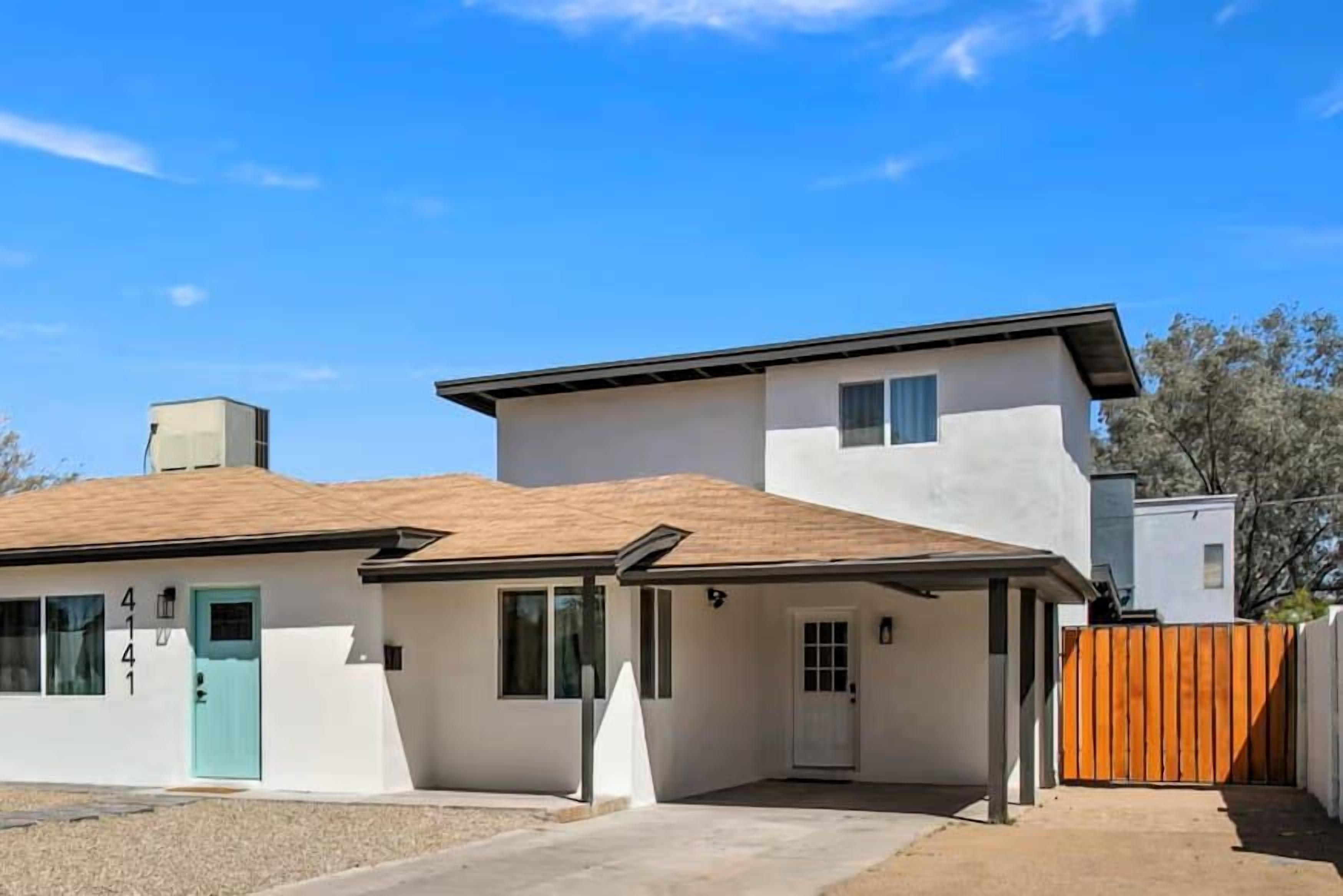 A two-story residential building with a covered porch, a front door, and a garage.