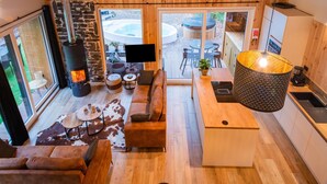 A cozy living area with a fireplace, a sofa, a TV, and a dining table with chairs. - Escape With Heated Pool (Erezee)