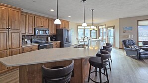 A spacious kitchen with a large island, wooden cabinets, and modern appliances.