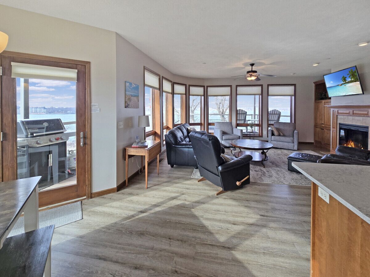 A spacious living area with a fireplace, a dining table, and a seating area with a sofa and chairs.