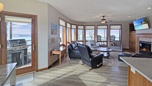 A spacious living area with a fireplace, a dining table, and a seating area with a sofa and chairs.