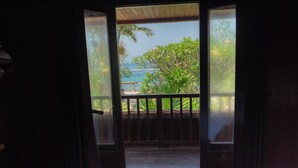 A room with a bed and a view of the ocean through an open door. - The Ariras Resort (Karangasem)