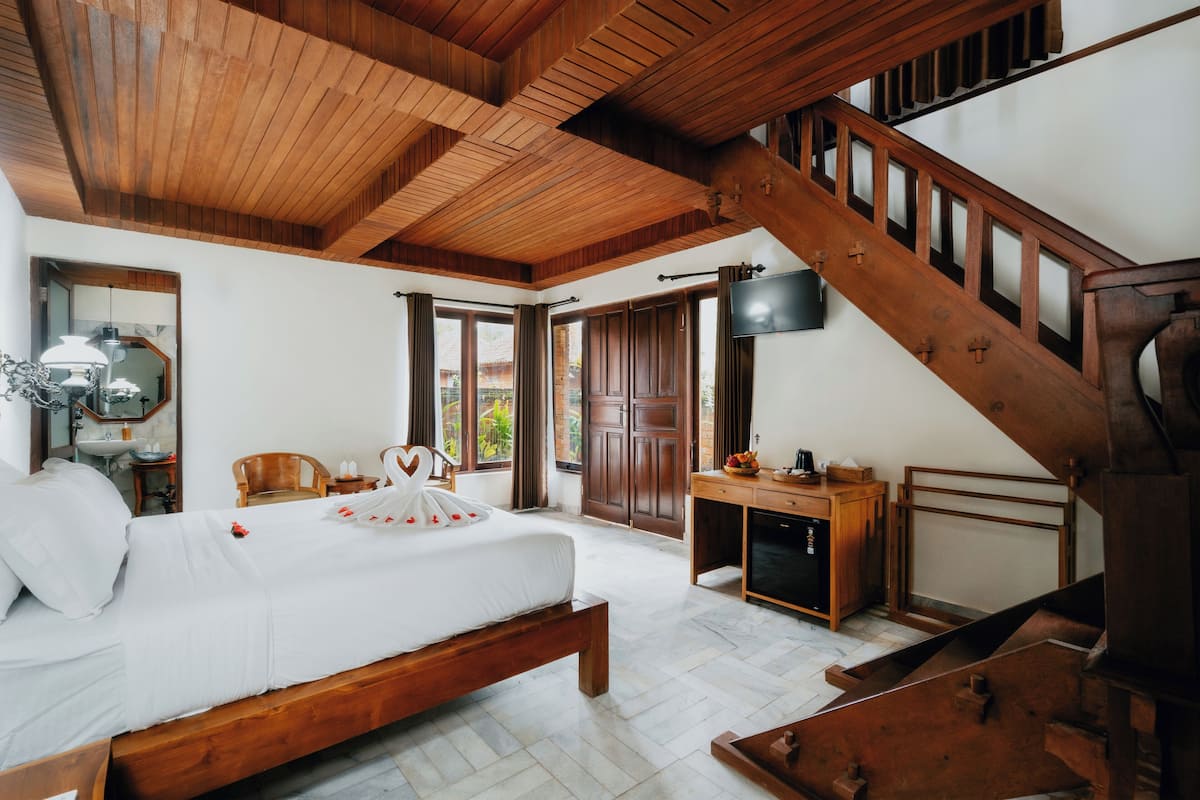 Una camera da letto con un letto di legno, una scrivania e una scala.