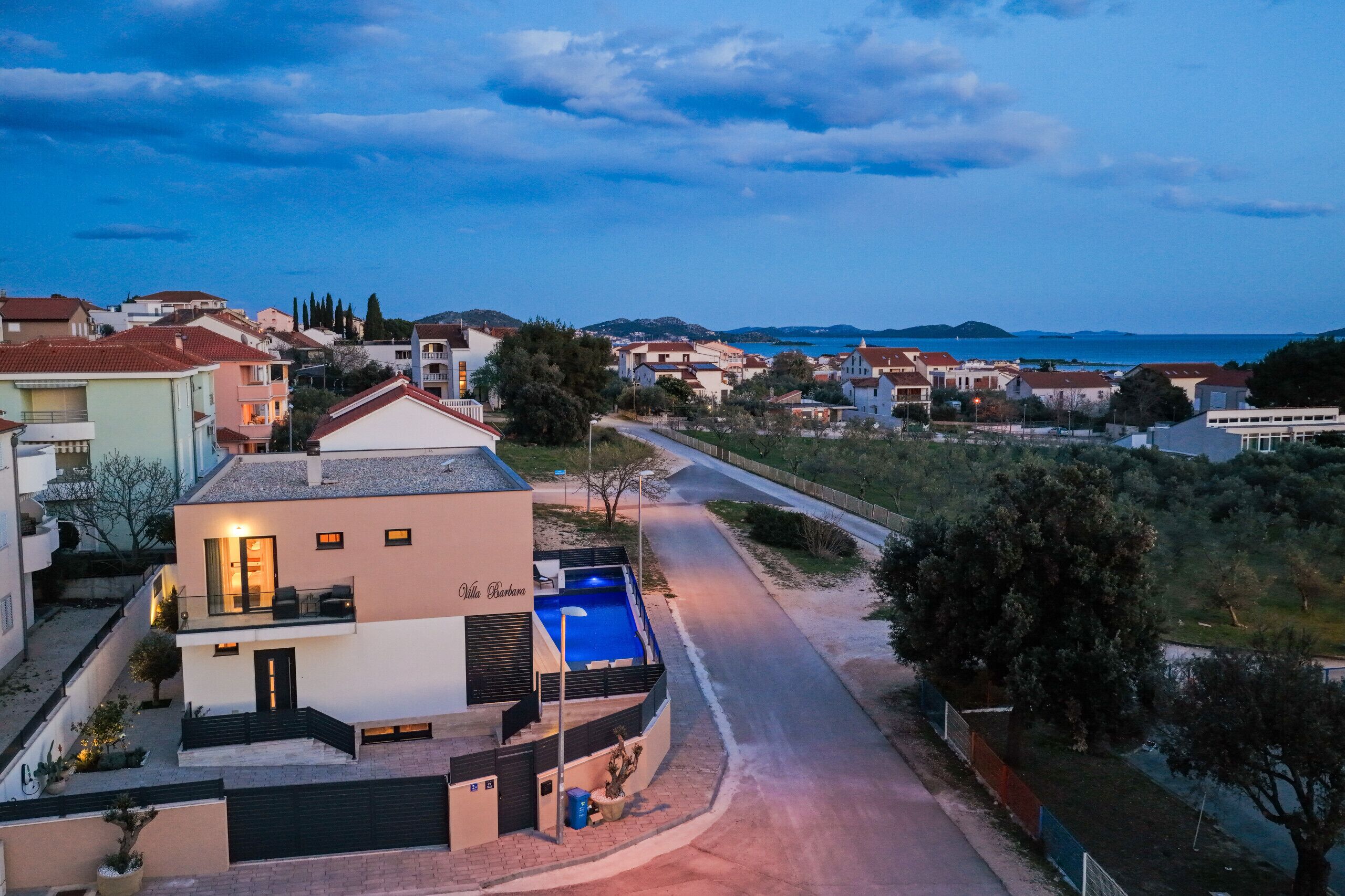 A residential area with houses, a road, and a pool.