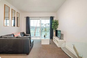 Relax in this stylish living room with a black leather sofa, coffee table, and flat-screen TV.