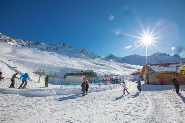 A ski resort with snow-covered slopes, a ski lift, and a wooden building.