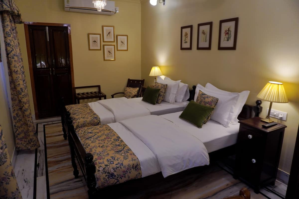 Una cama doble con ropa de cama floral, una mesita de noche con lámpara y un armario.