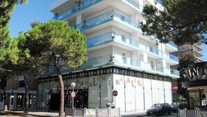 A multi-story building with a modern architectural design, featuring balconies and large windows.