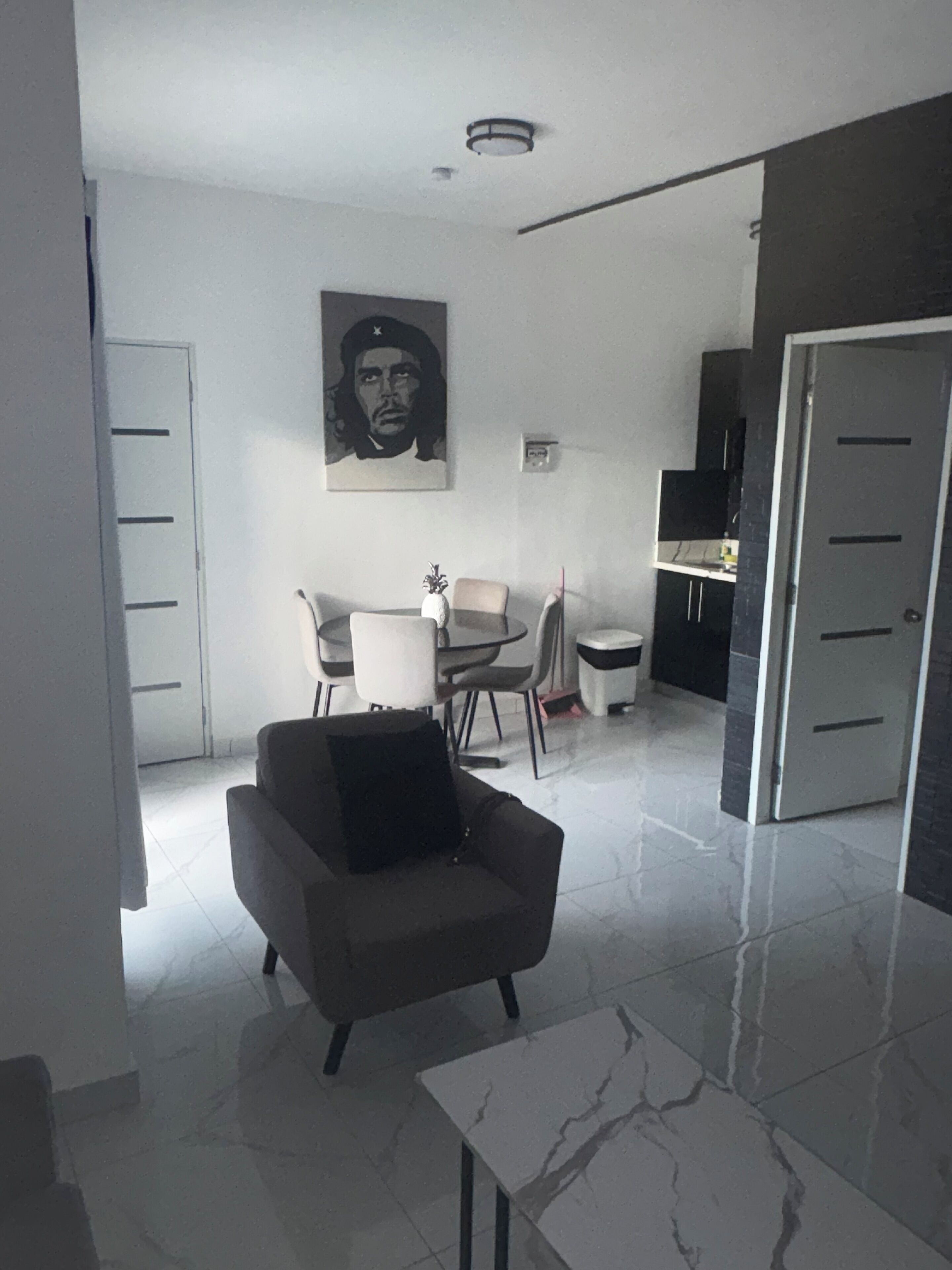 Un salon moderne avec un canapé, une petite table et un coin repas avec des chaises.