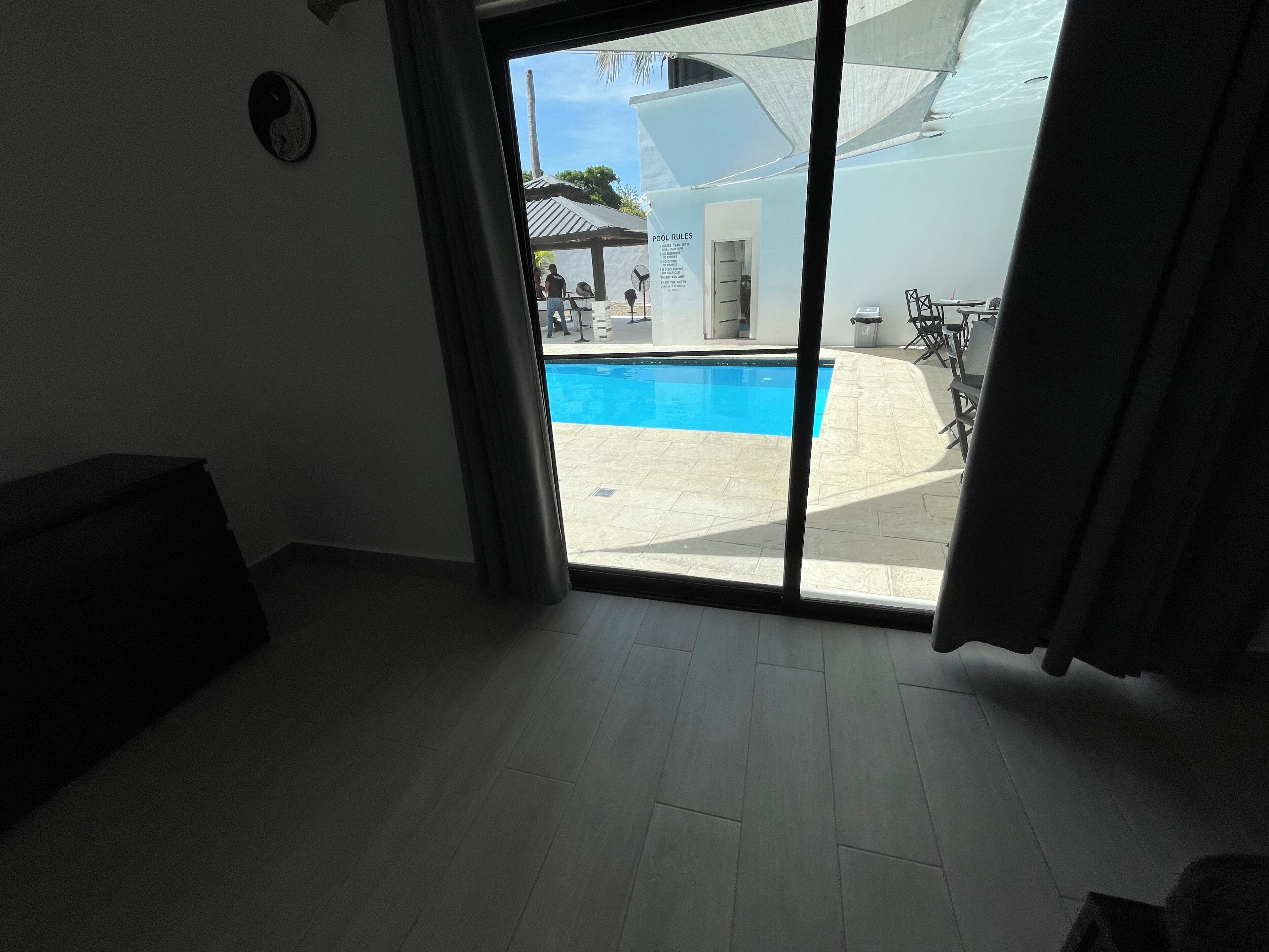 Habitación con vistas a una piscina, un espacio exterior cubierto y una puerta que da al exterior.