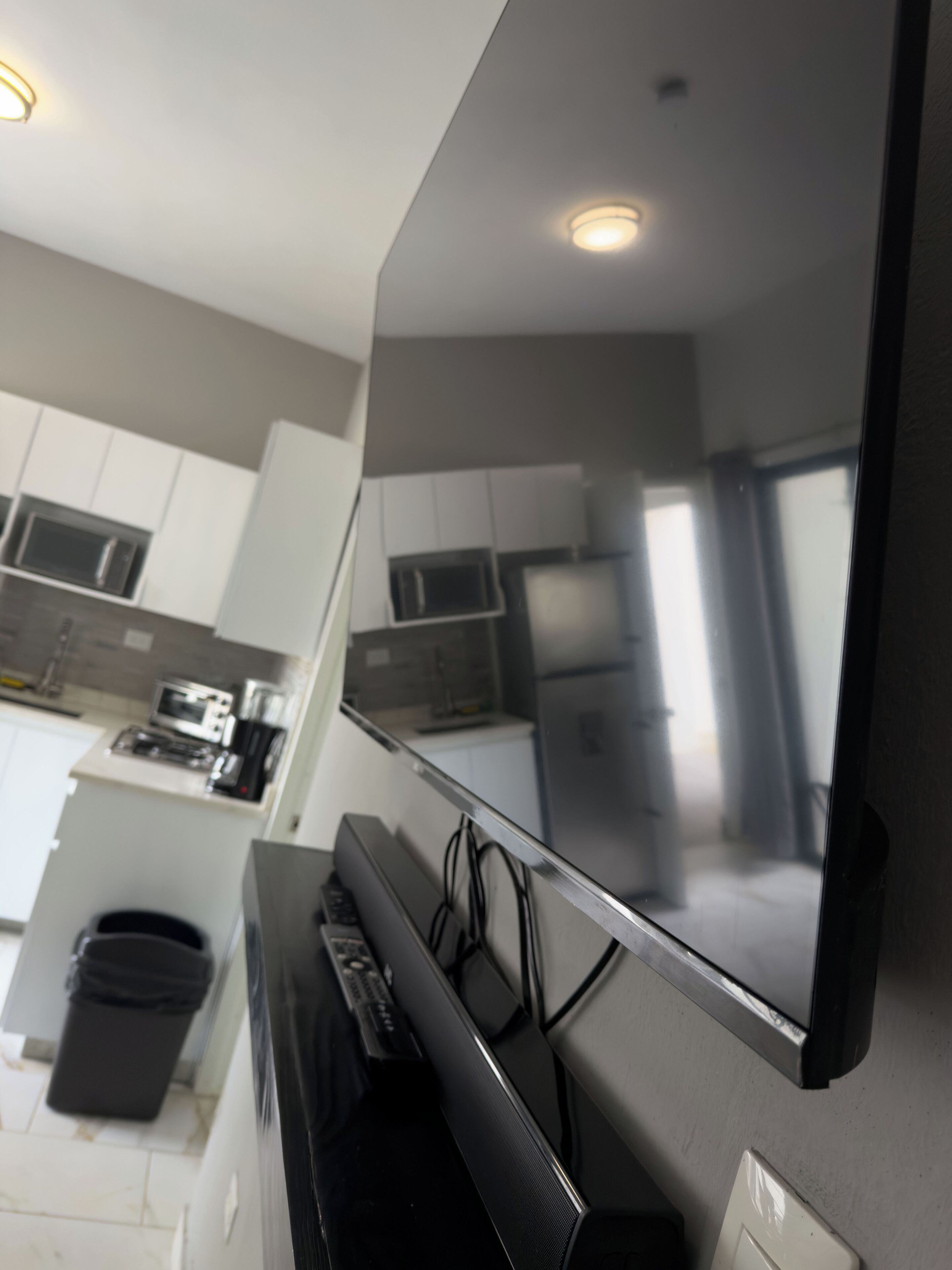 Una cocina moderna con armarios blancos, un microondas y un refrigerador.