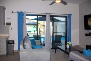 Suite Luxury, patio, lato piscina | Area soggiorno | Smart TV 65 pollici con canali digitali, Netflix, film pay-per-view
