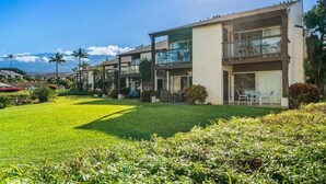 A modern two-story hotel with a flat roof, large windows, and a well-maintained lawn.