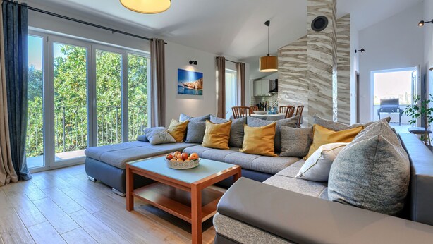 En moderne stue med sofa, sofabord og spiseområde.