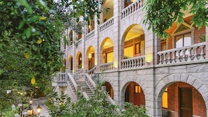 A multi-story building with stone architecture, featuring arched windows and a central staircase. - Living Sense Linghai Hotel (Xiamen)