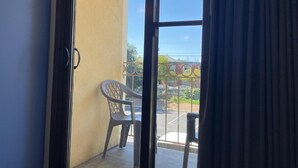 Une pièce dotée d’une porte-fenêtre coulissante donnant sur un espace extérieur aménagé avec une chaise et une table.