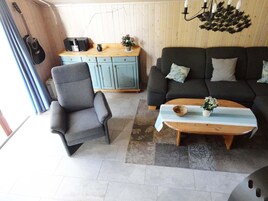 A cozy living room with a grey sofa, a wooden coffee table, and a blue cabinet.