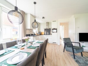 Eine moderne Küche mit weißen Schränken, einem eingebauten Backofen und einem großen Fenster.